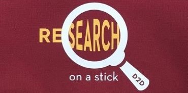 magnifying glass over the word "research," distorting letters. The words read: Research on a stick - D2D